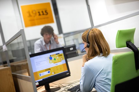 A woman and a man are sitting at computers in a open space in the office 