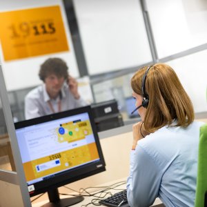 A woman and a man are sitting at computers in a open space in the office 